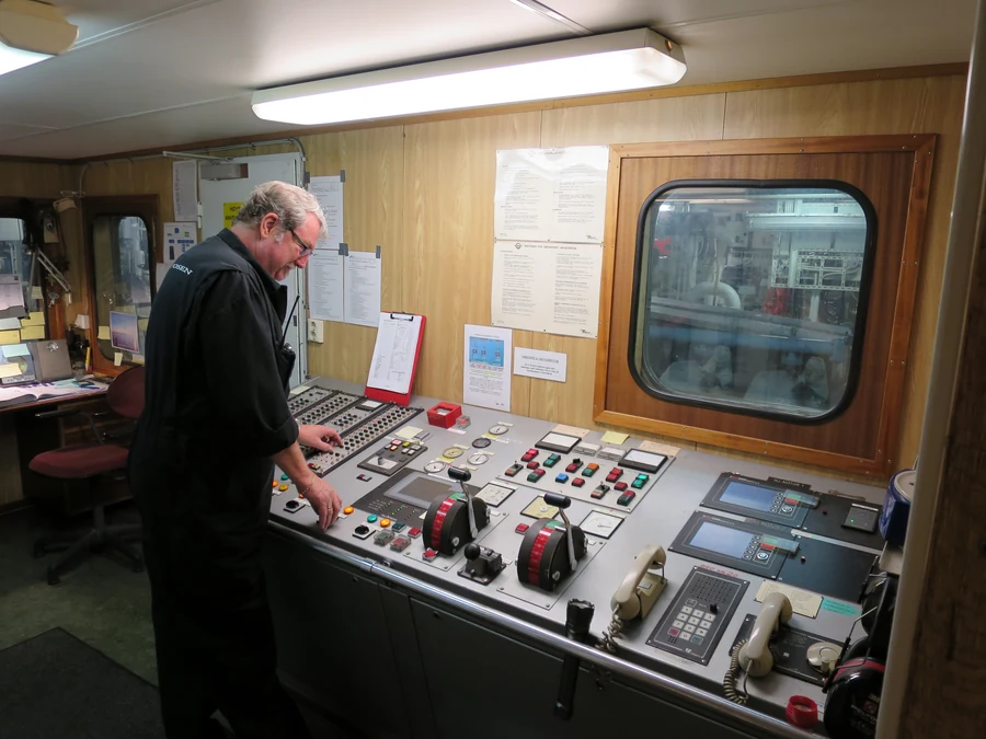 The engine room on the ferry MF Bastø IV, the chief engineer on watch at the left of the control room panel.