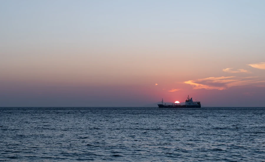 The tanker APILIOTIS leaving Tinos, Greece, at sunset. Illustrative photograph.
